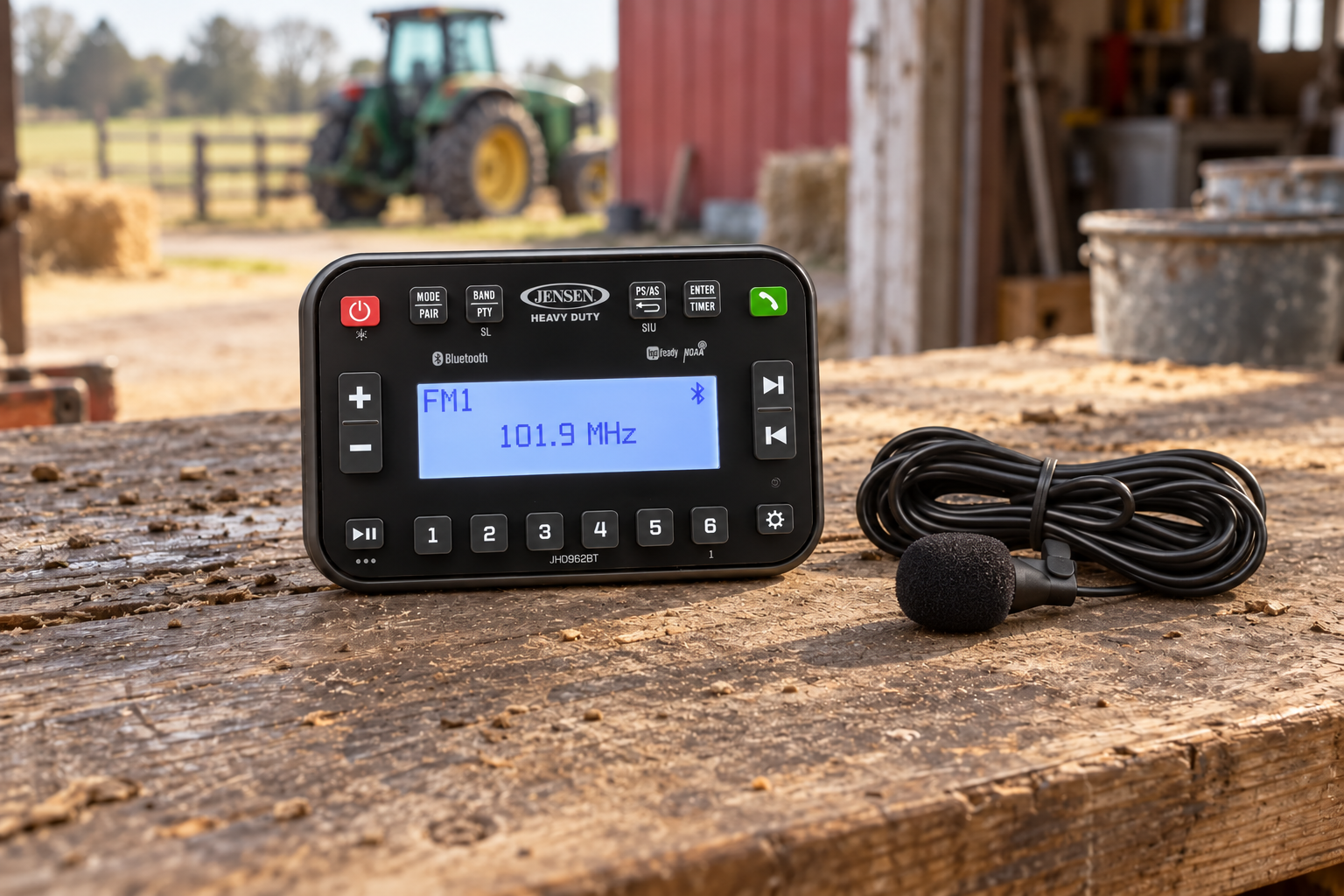 Jensen JHD962BT with JMICHFP15 Microphone Compact Jensen JHD962BT Bluetooth radio with JMICHFP15 hands-free microphone displayed on a rustic outdoor workbench.